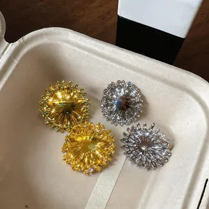 Vue rapprochée de quatre broches fleurs en zircone rayons de soleil en or et argent