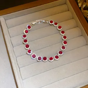 Nahaufnahme eines roten Zirkon-Armbands mit silberner Blumenfassung in Schmuckschale