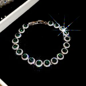 Detailansicht eines luxuriösen Zirkonia-Armbandes mit grünen Steinen und Glitzereffekten.