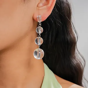 Gros plan détaillé d'élégantes boucles d'oreilles triple goutte en cristal sur modèle