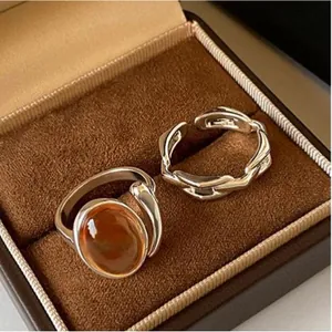 Silver-tone open ring set with amber-colored stone and link chain detail