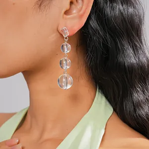 Vue détaillée de boucles d'oreilles pendantes en perles de cristal transparent