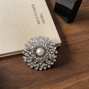 Gros plan d'une élégante broche plaquée or 18k avec fleur en zircon et perle