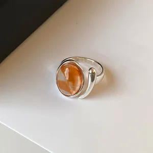 Detailed view of minimalist silver adjustable ring with orange watercolor stone inlay