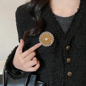Gros plan d'une élégante broche florale en zircon et perle sur une veste en tweed noir.