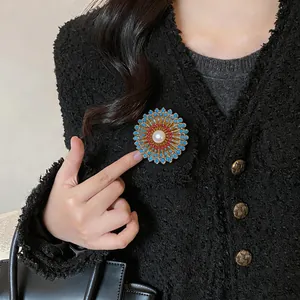 Vue détaillée d'une luxueuse broche fleur en plaqué or 18k avec perle sur veste en tweed