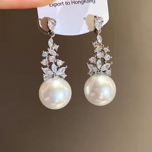 Close-up of vintage silver zircon pearl drop earrings with elegant white pearl detail