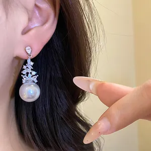 Close-up of vintage silver earring with sparkling zircons and a large white pearl pendant.
