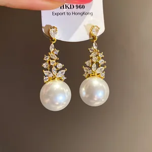 Close-up detail of elegant vintage gold-toned earrings featuring sparkling zircons and pearls