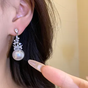 Close-up detail of vintage silver needle earring featuring zircon flower and large white pearl
