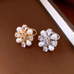 Elegant 14k gold plated pearl and zircon flower open ring set on brown background