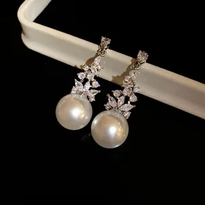 Elegant vintage-style drop earrings featuring large white pearls and floral zircon accents.