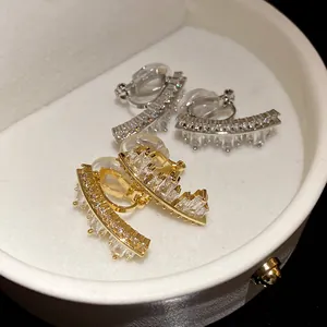 Detail view of irregular geometric ear clips with sparkling zircons in a jewelry box