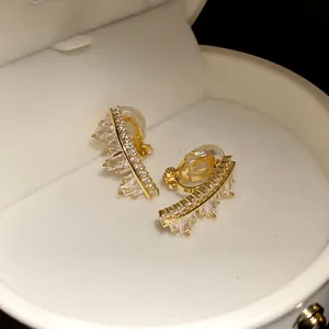Detailed close-up view of elegant gold clip-on earrings featuring irregular geometric zircon
