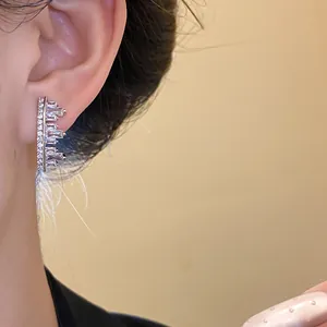 Detailed macro view of geometric silver earrings with irregular clear zircons
