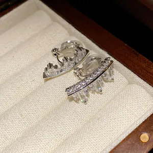 Macro view of irregular geometric zircon ear clips displayed in a jewelry box