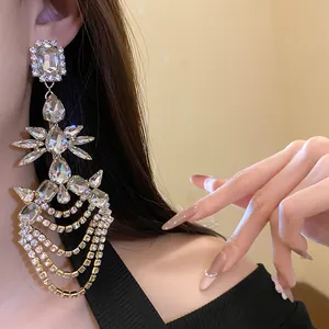 Primo piano di orecchini a nappa con strass e gemme a goccia in tonalità argento.
