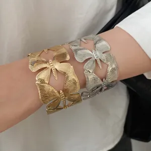 Detail of vintage butterfly cuff bracelets with textured gold and silver finishes