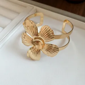 Macro detail view of vintage gold flower cuff bracelet with intricate metal petal texture