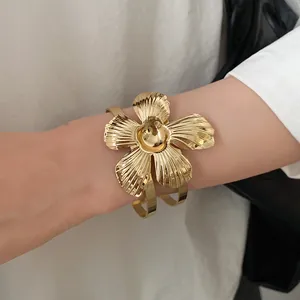 Close-up shot of a vintage gold flower cuff bracelet featuring leaf textured petals