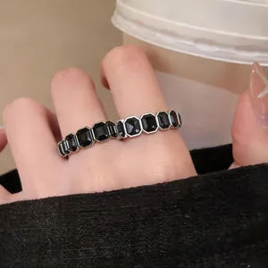 Dettaglio di un anello vintage con pietre nere ottagonali indossato sulle dita