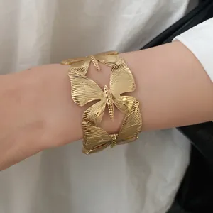 Detailed view of vintage golden metal butterfly wing open cuff bracelet for women