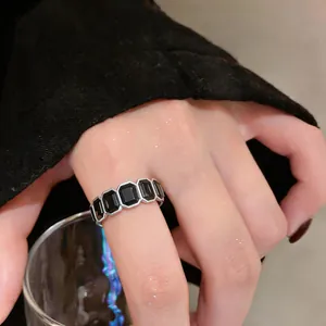 Dettaglio di un anello aperto vintage in argento con pietre esagonali nere incastonate.