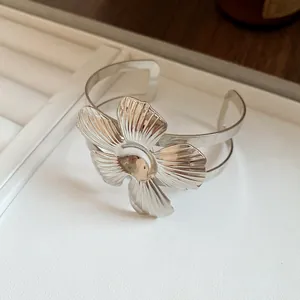 Detailed macro view showing the intricate leaf pattern on silver flower cuff bracelet