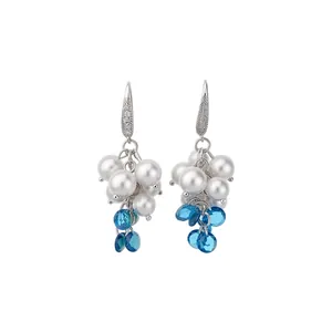 Eleganti orecchini a gancio con perle bianche e gocce di zircone blu su sfondo bianco