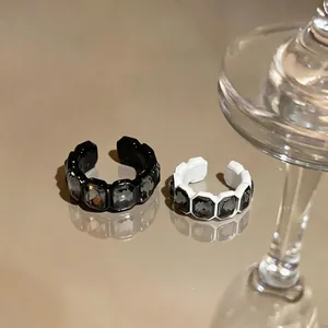 Primo piano di anelli aperti vintage eleganti con strass esagonali in nero e bianco