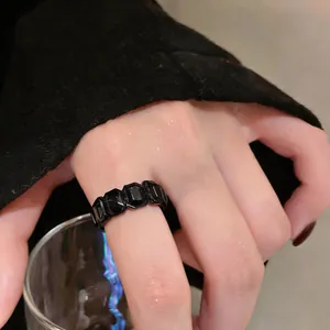 Vista dettagliata di un elegante anello retrò con pietre esagonali nere al dito