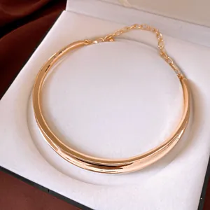 Detailed view of an elegant gold irregular metallic choker necklace inside a white jewelry box.