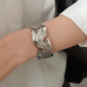 Detailed macro view showing the intricate leaf texture of this silver metal open cuff bracelet
