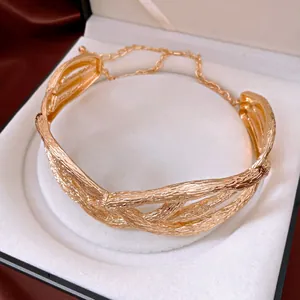 Close-up of irregular gold intertwined necklace with wrinkled metal texture in jewelry box