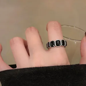 Primo piano di un anello vintage esagonale con pietre nere sulla mano