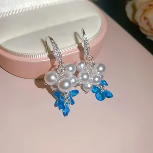 Dettaglio di orecchini a forma di uva con perle e cristalli blu in stile francese