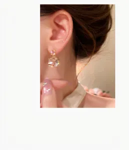 Eleganti orecchini in argento placcato oro 18k con zircone indossati da una modella asiatica