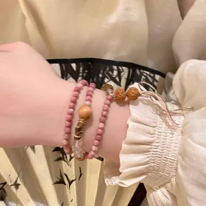 Elegant multilayer rhodochrosite beaded bracelet with boho wooden accents and tassel detail