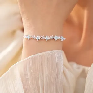 Elegant silver-toned bracelet featuring light blue and clear zircon star charms on a model wrist