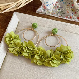Dettaglio degli orecchini a cerchio con fiori in chiffon verde chiaro per vacanza