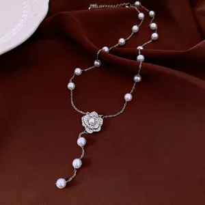 Elegant vintage pearl necklace with a zircon flower pendant on rich brown fabric