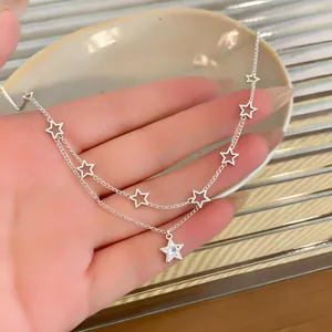 Detailed close-up of a silver double-layer necklace with zircon-studded star pendant