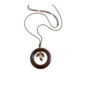 Vintage ethnic style circular necklace featuring bronze leaf pendant on a long brown cord