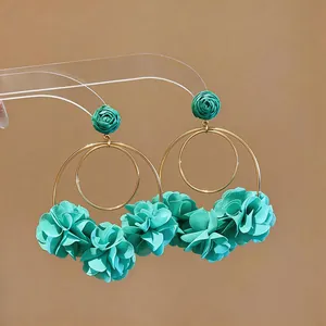 Dettaglio orecchini a cerchio con fiori in chiffon turchese e finitura dorata