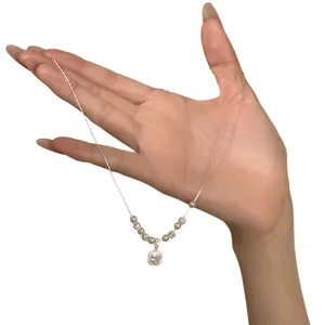 Elegant silver necklace featuring square zircon pendant and beads shown on a hand