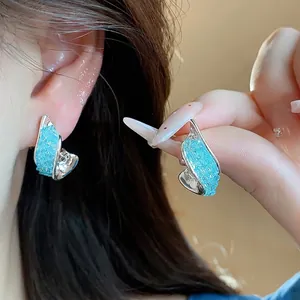 Elegant irregular silver needle stud earrings with light blue crushed glass texture