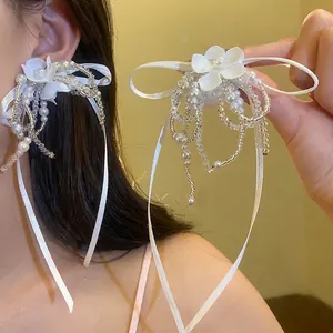 Elegant white flower bow earrings with pearl and bead tassels in main view