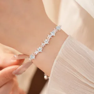 Close-up shot of a delicate zircon star adjustable bracelet worn on a wrist with textured sleeve