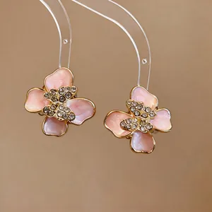 Detailed view of pink enamel flower earrings with crystal butterfly center
