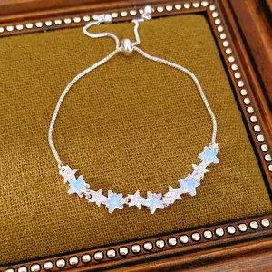 Detailed close-up of an adjustable zircon star bracelet with light blue accents.